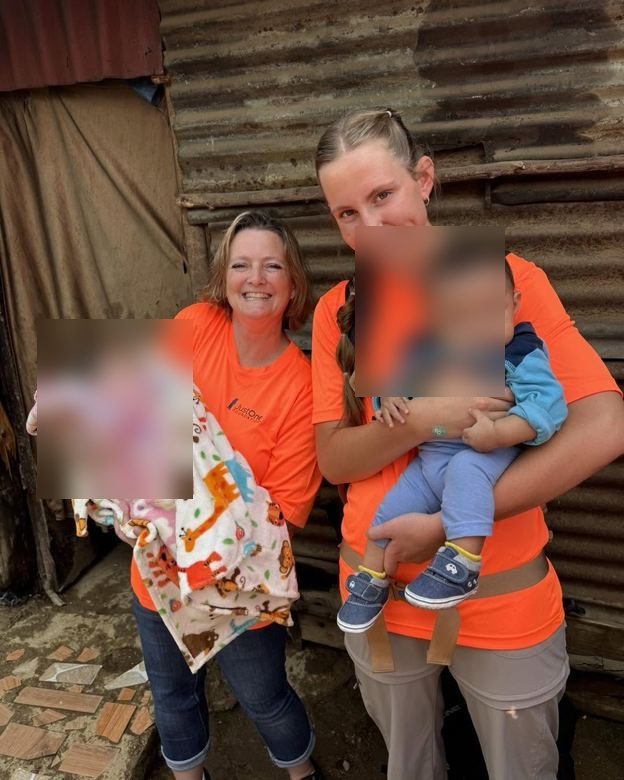 Volunteers with a family and a new blanket