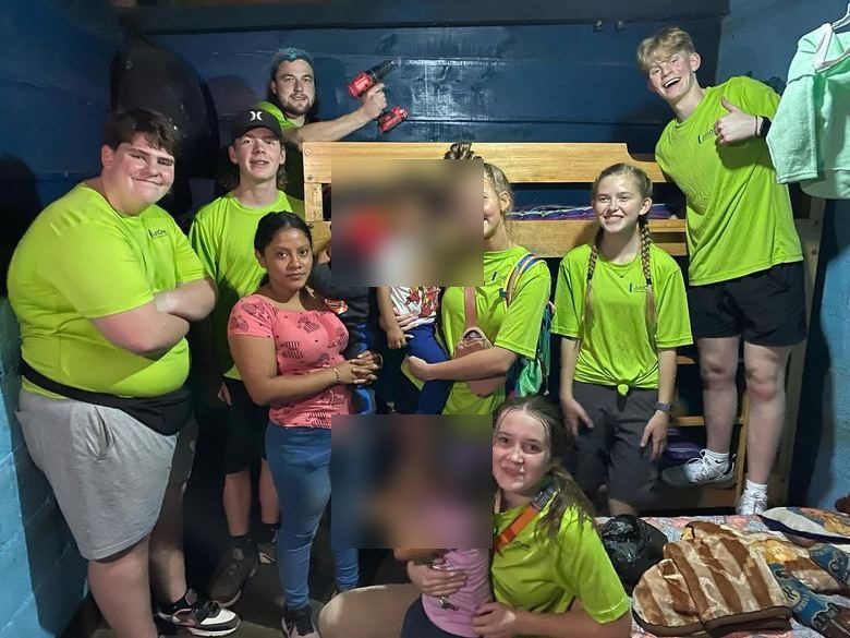 Children and volunteers by a new bunk bed